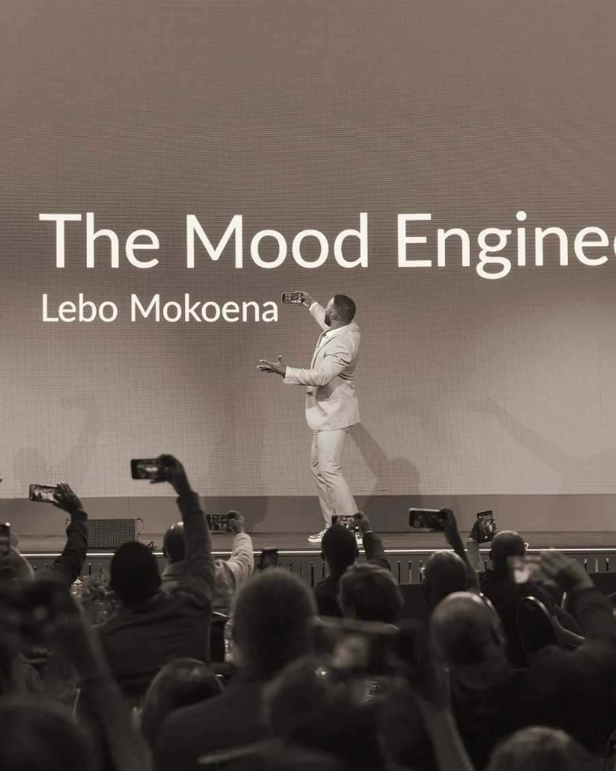 A full room on its feet, phones raised, as Lebo Mokoena takes a selfie from the stage